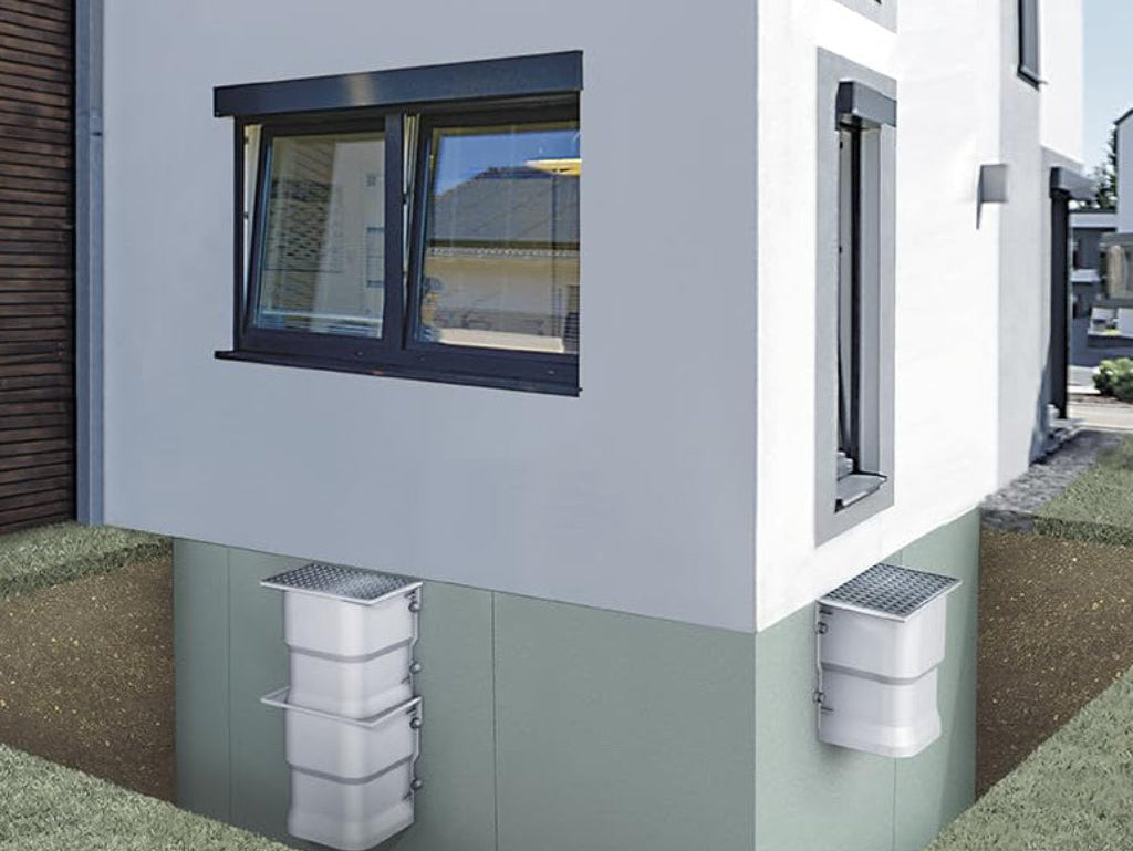 Deux courettes d’aération SMC installées – solution durable et efficace pour ventiler et assainir naturellement les sous-sols humides.